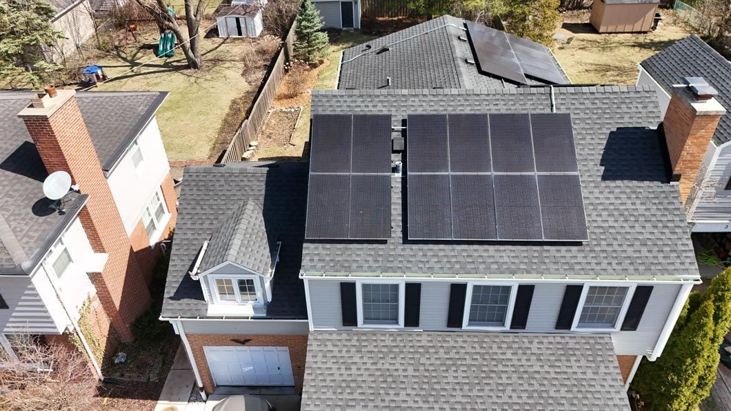Overhead view of a house with gray roof and black solar panels.