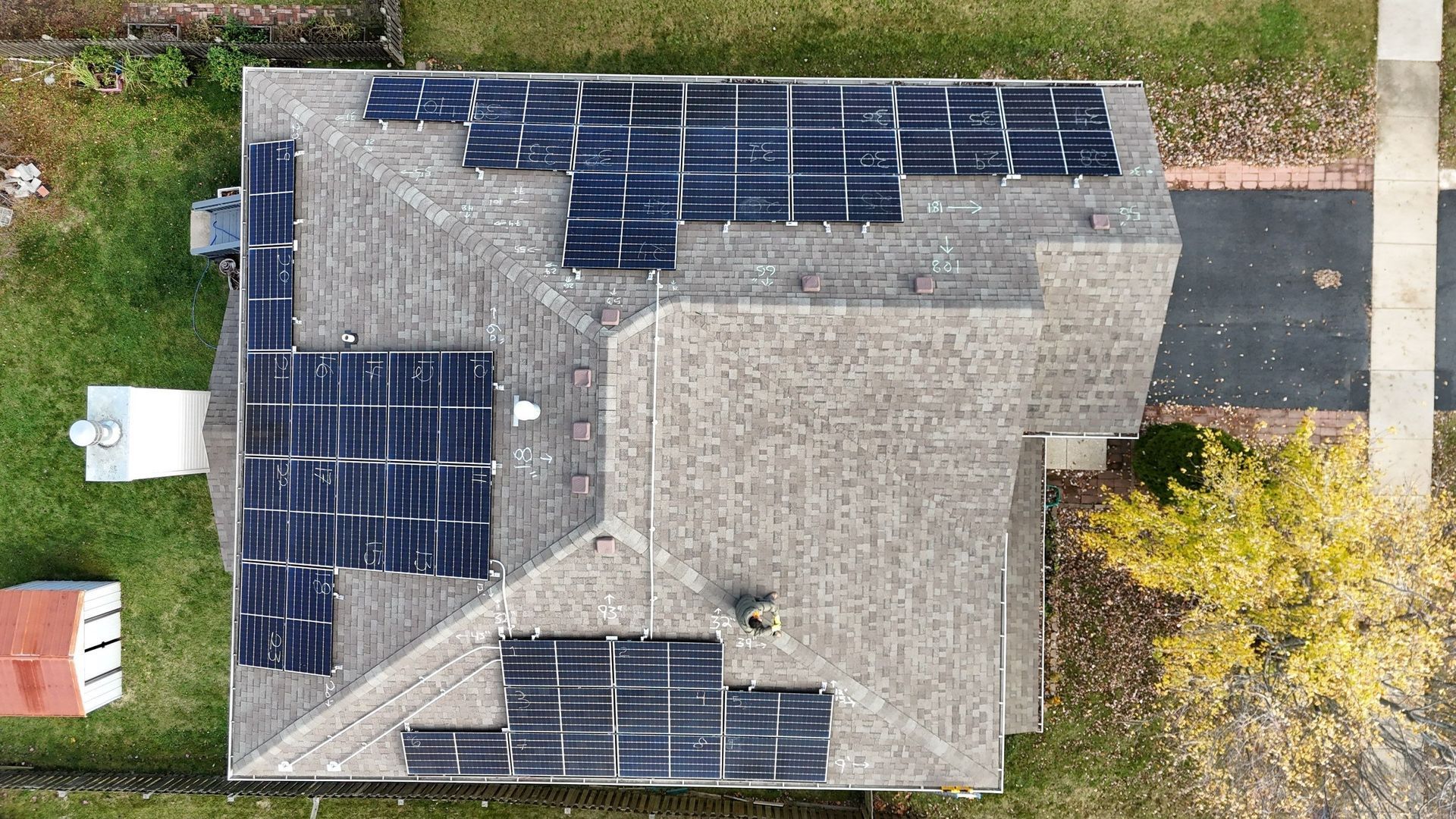 Overhead view of a house roof covered in solar panels.