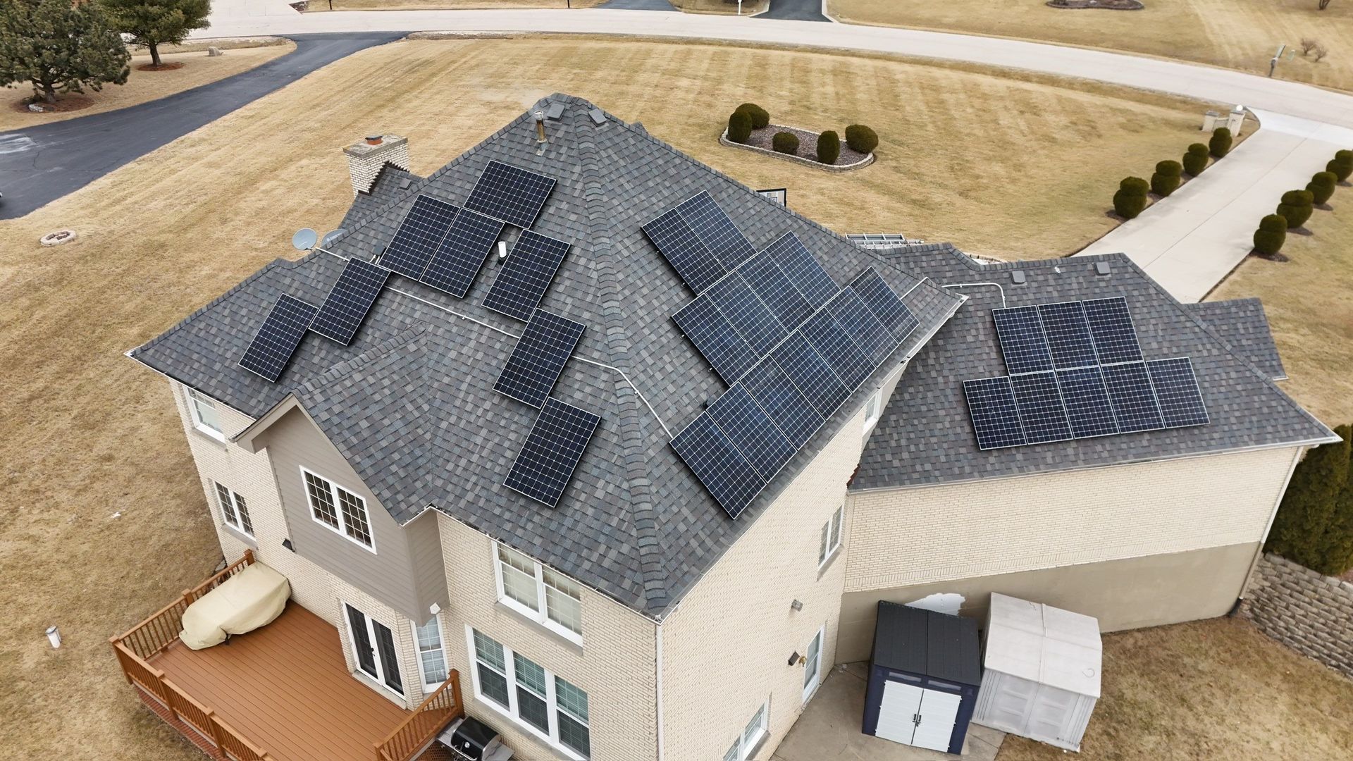 House with solar panels on the roof, situated in a suburban setting.