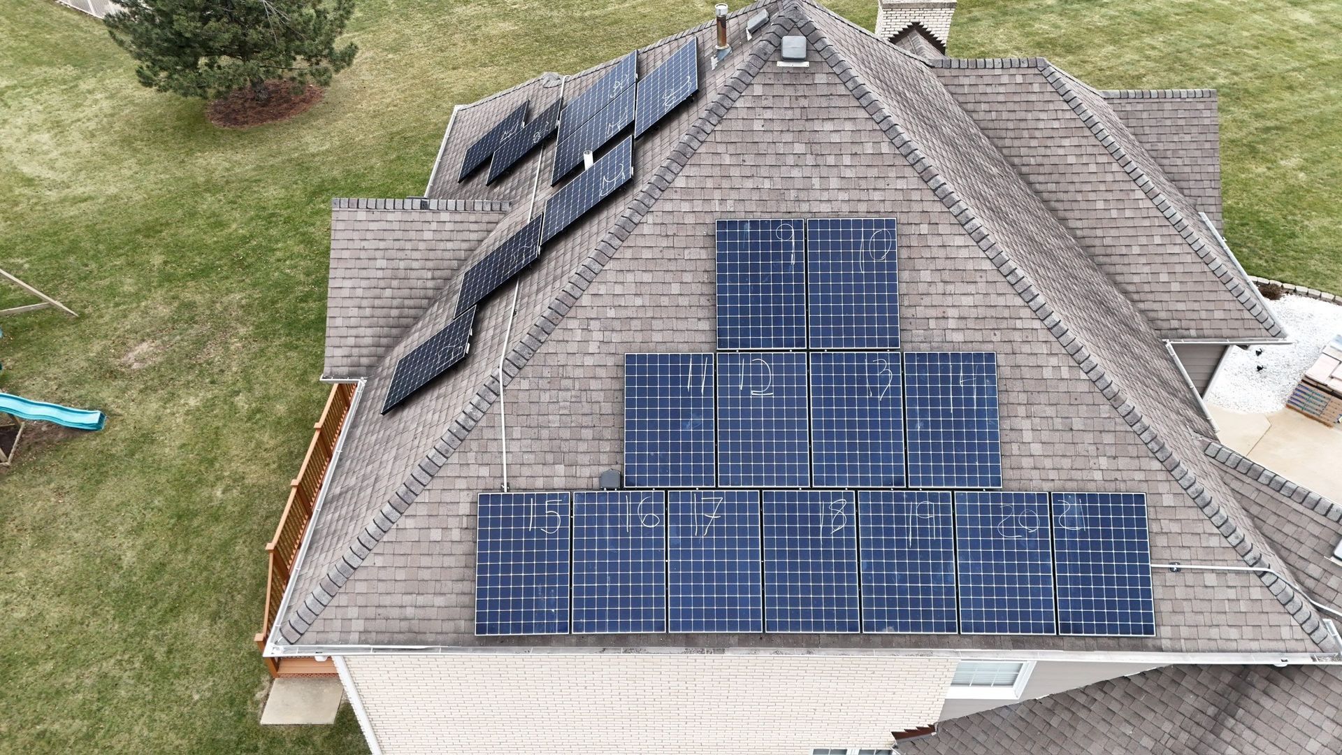 Solar panels installed on a residential rooftop. Panels are black and blue. The roof is brown.