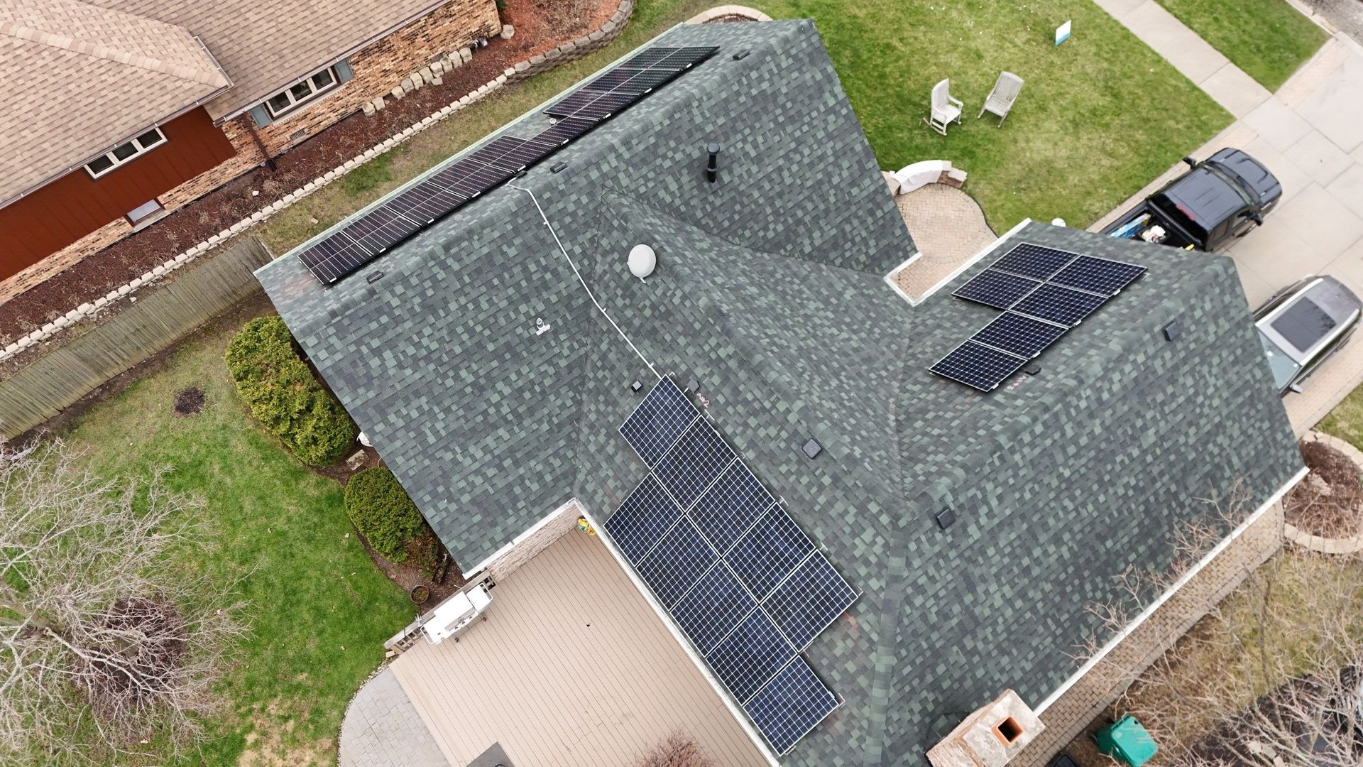 Aerial view of a house with solar panels on its roof.