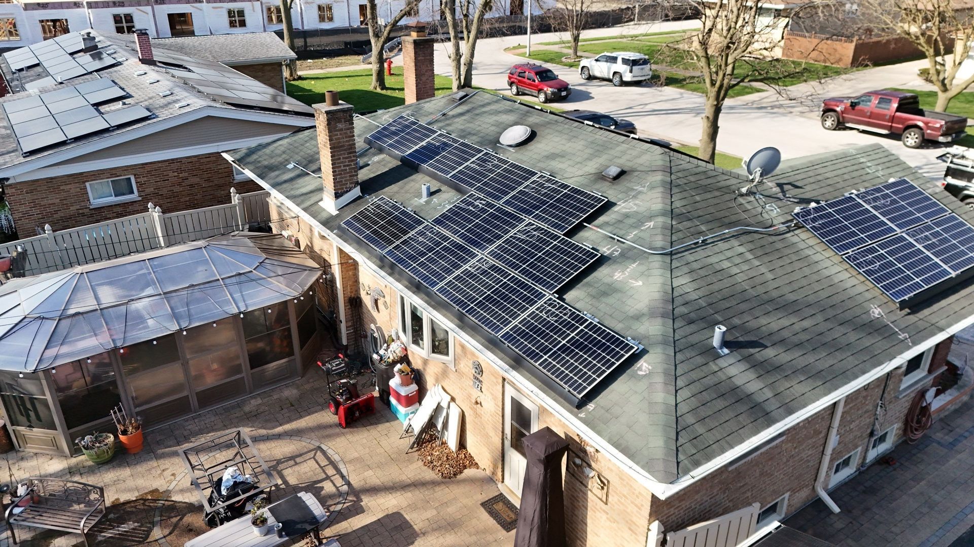 Solar panels on a house roof in a residential neighborhood, sunny day.