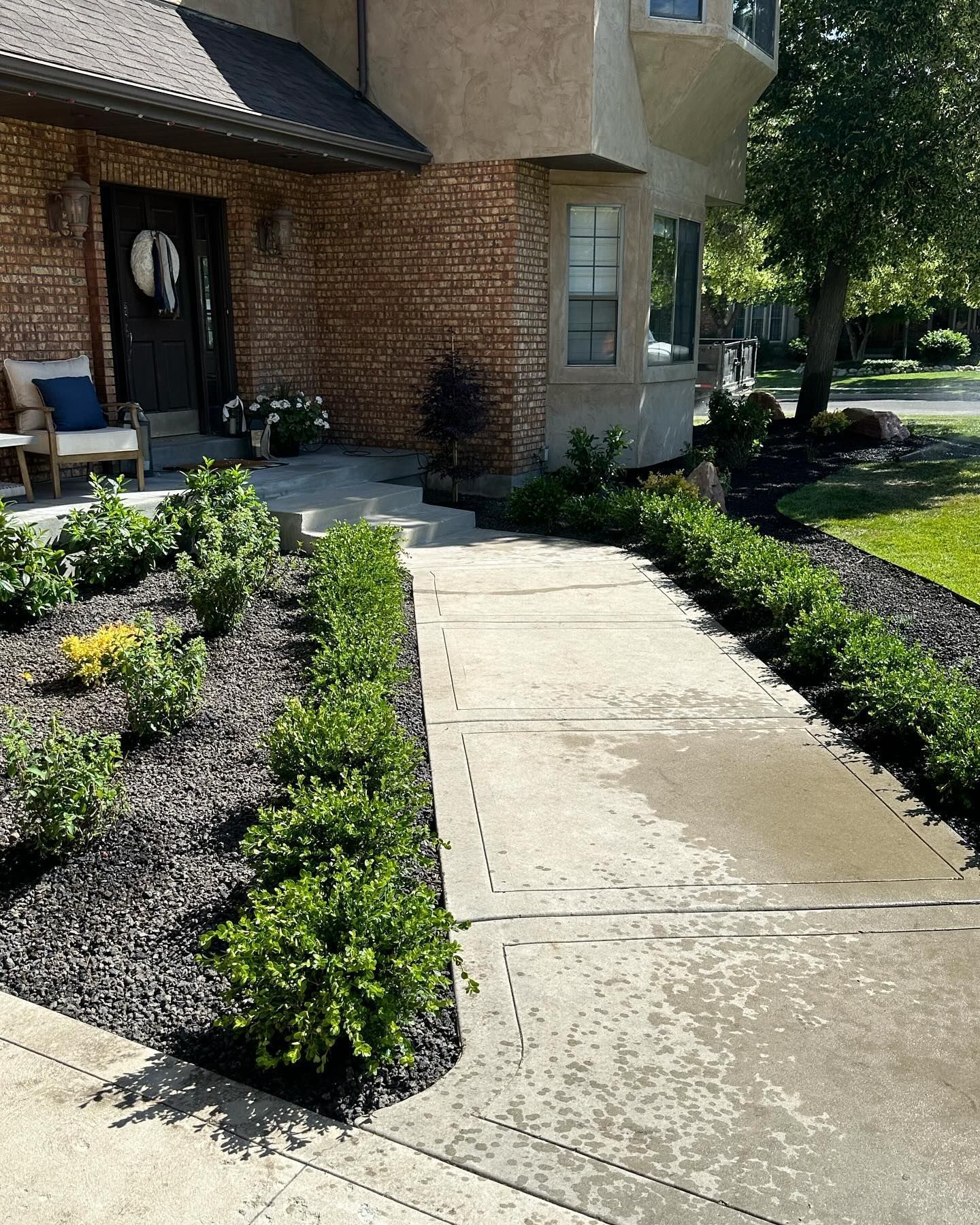 A brick house with a walkway leading to the front door