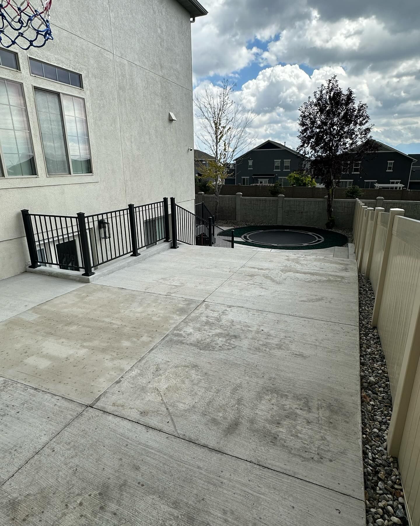 A patio with a fence and a pool in the backyard of a house.