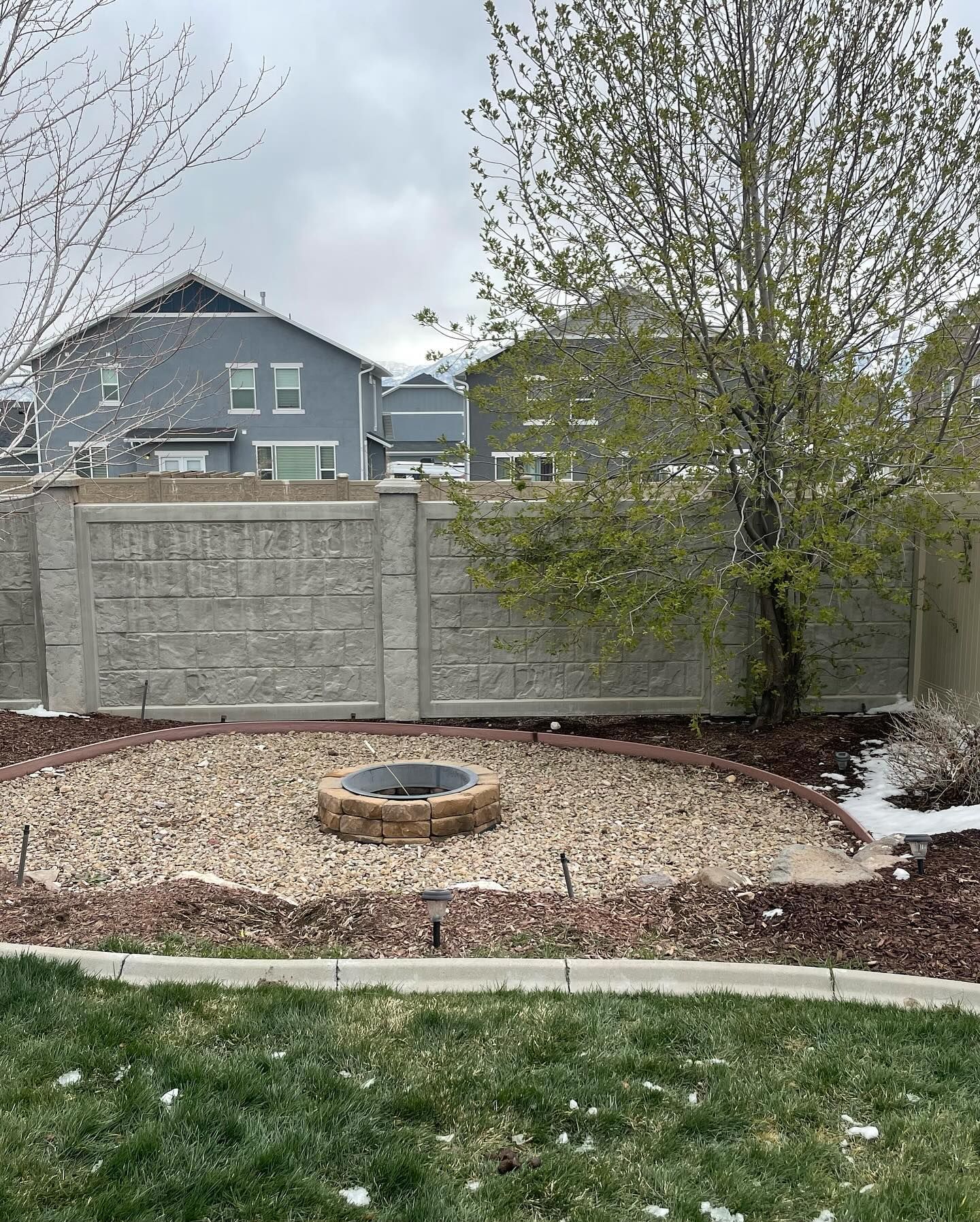 There is a fire pit in the middle of the backyard.