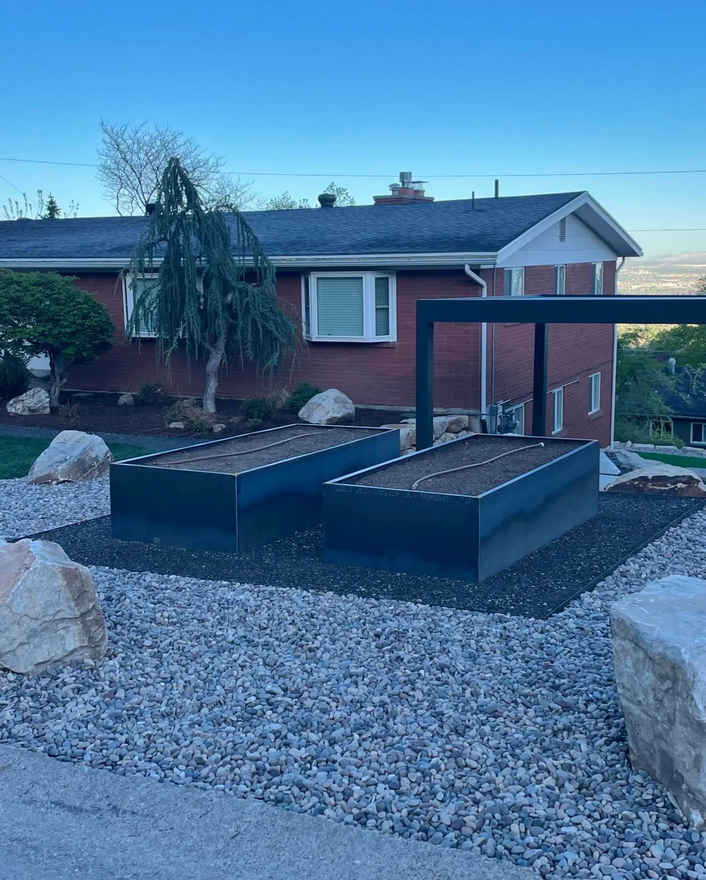 A brick house with two raised beds in front of it