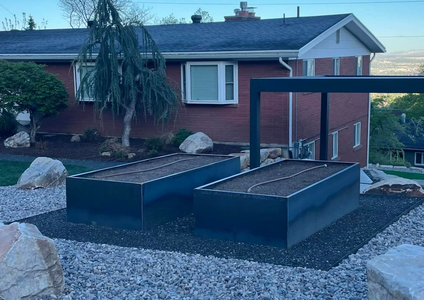 A brick house with two raised beds in front of it