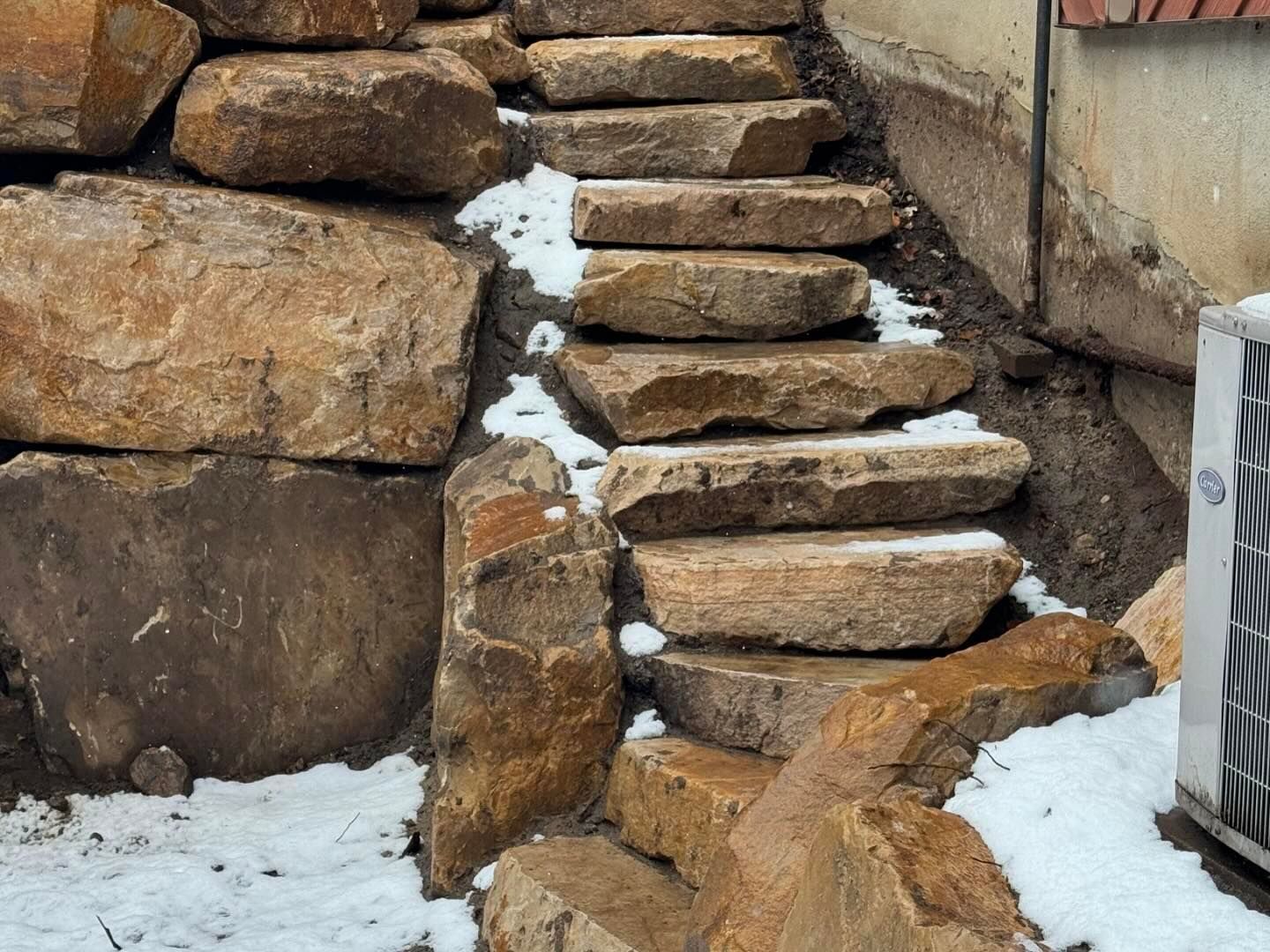 A set of stairs made of rocks leading up to a building