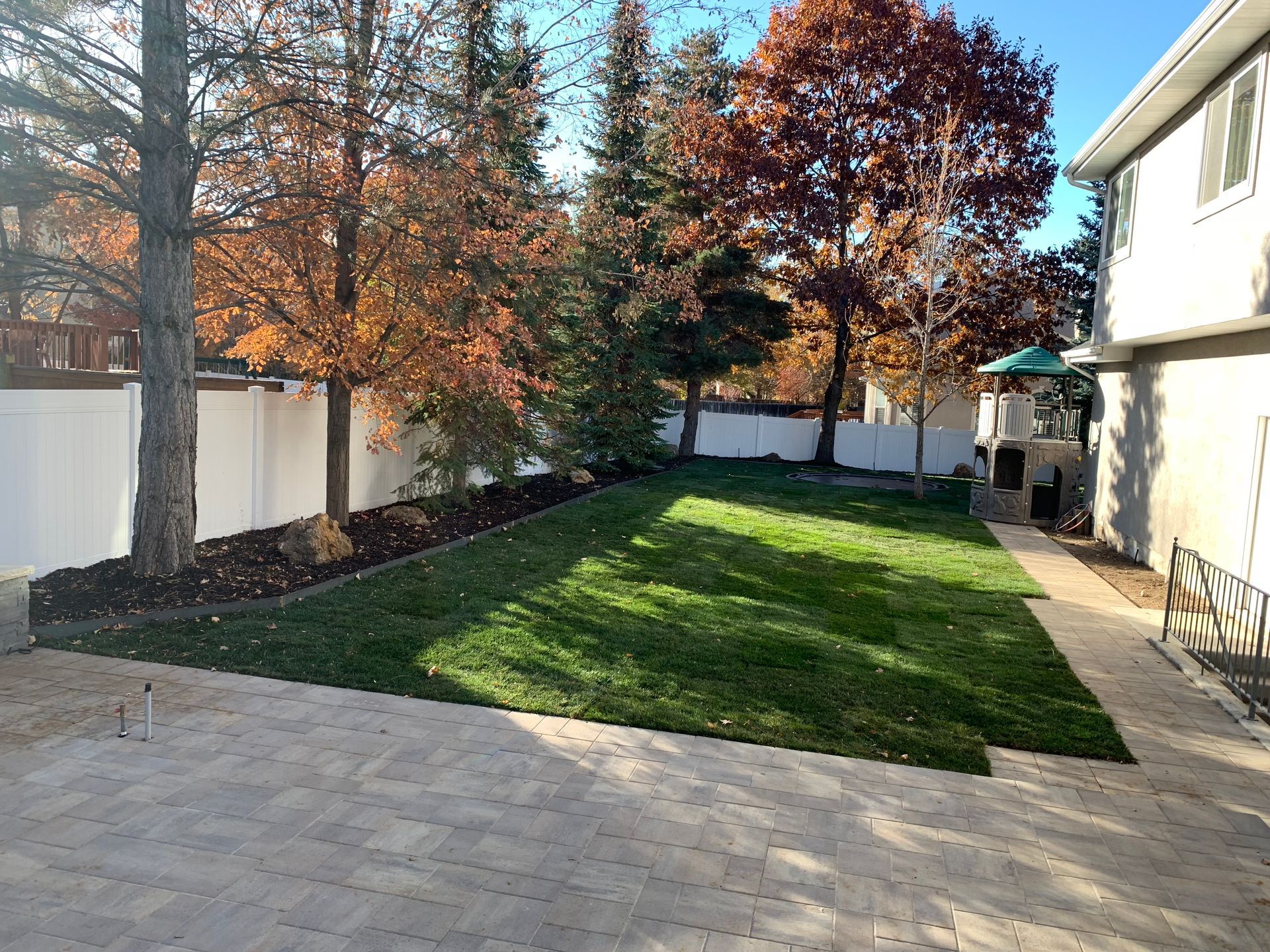 A rock wall is being built in front of a brick house.