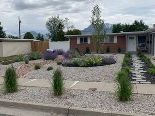 A house with a large window and a wooden deck underneath it.