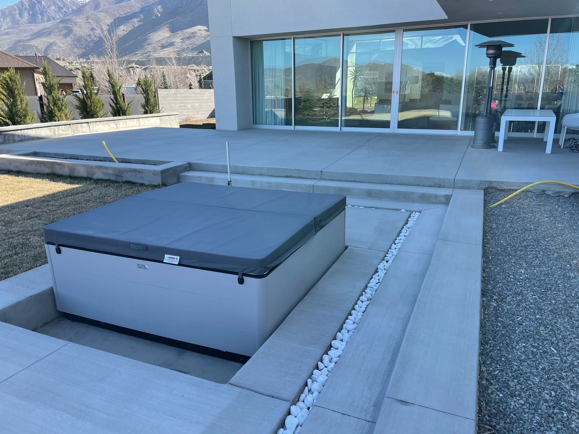A hot tub is sitting in the backyard of a house.