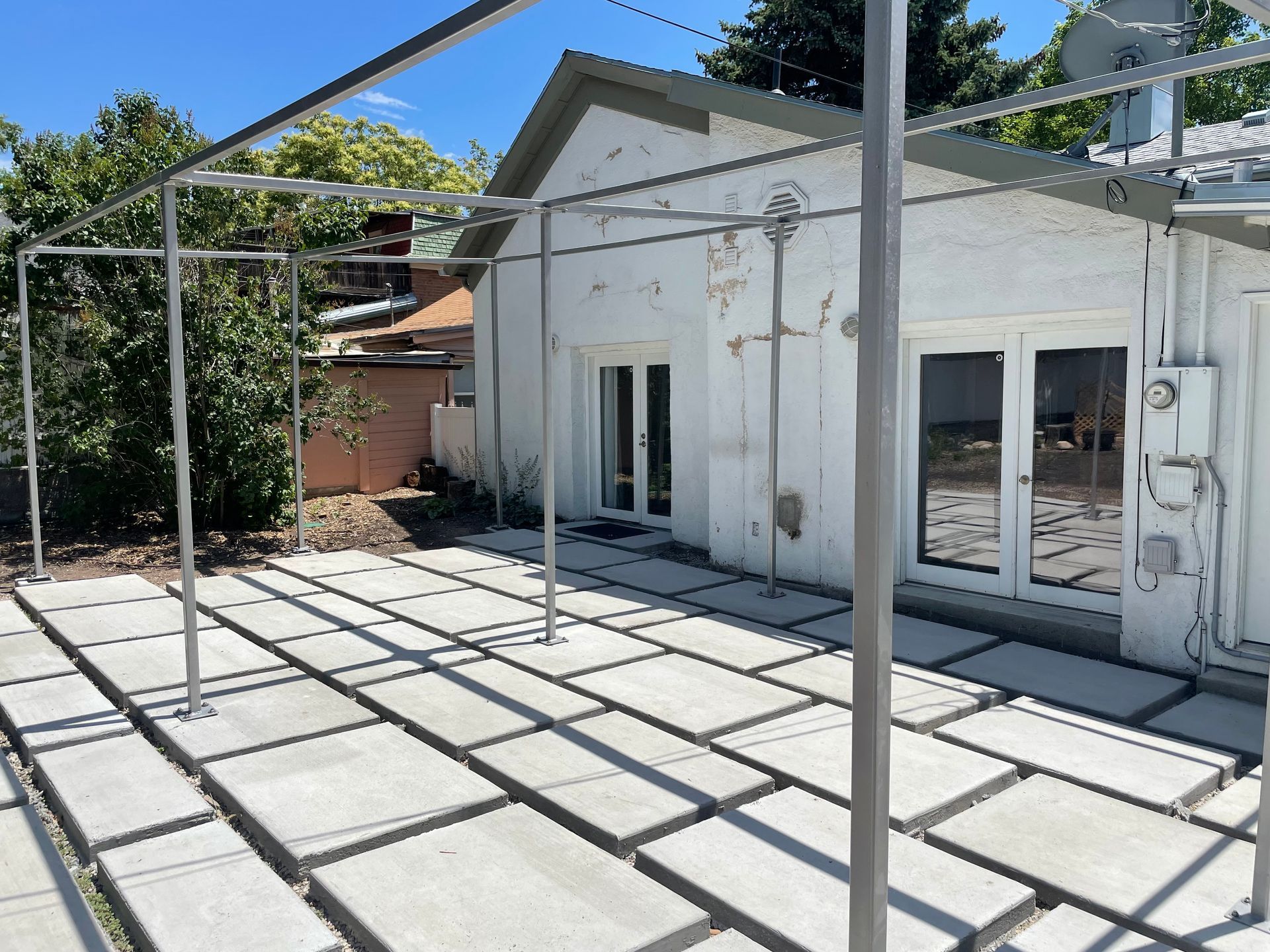 A red house is surrounded by trees and bushes in the middle of a forest.