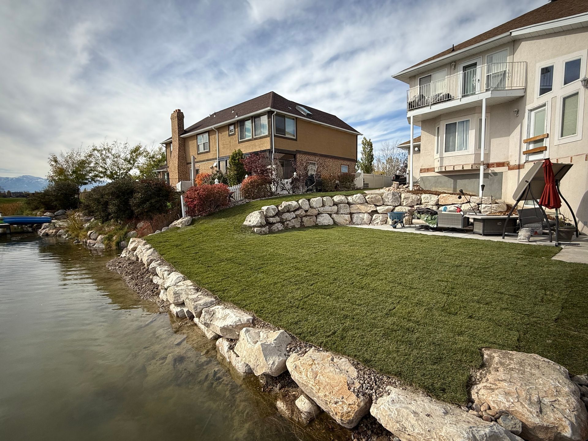 A backyard with a white fence and mountains in the background