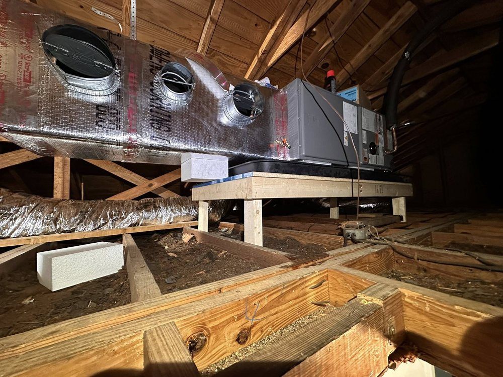 Insulated HVAC ductwork and equipment installed in an attic with exposed wooden rafters