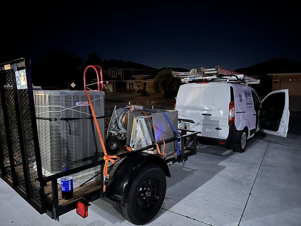 Utility trailer loaded with equipment hitched behind a white van at night on a residential street