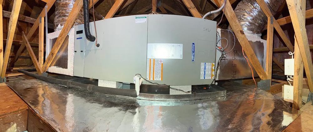 Large white HVAC unit installed in an attic with exposed wooden rafters and ductwork