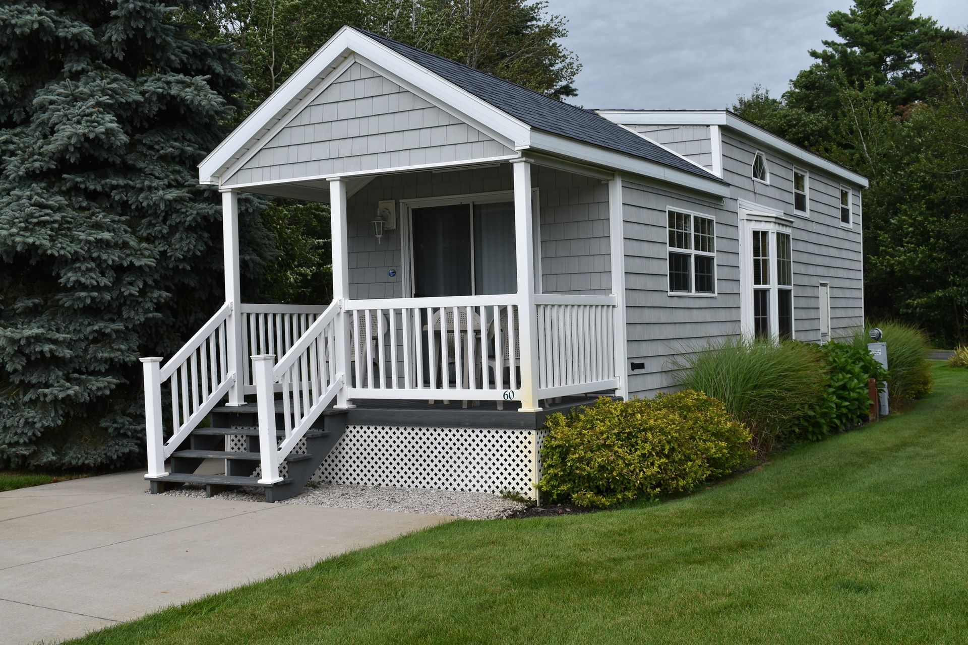 A small white house with a porch and stairs