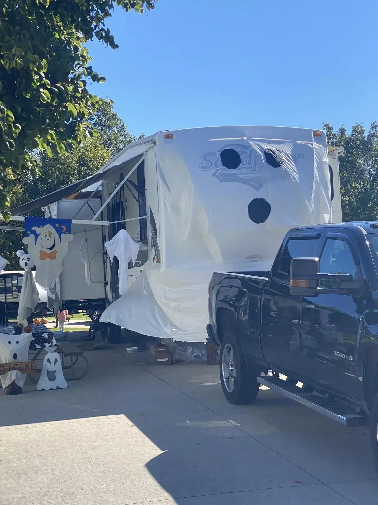 A truck is parked next to a trailer that has been decorated for halloween.