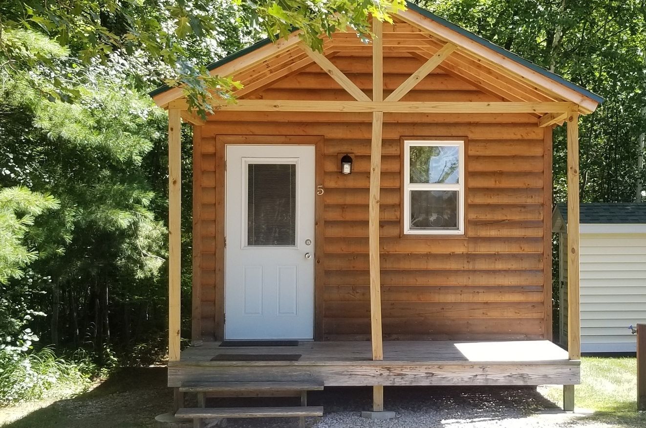 A small log cabin with a porch and a window