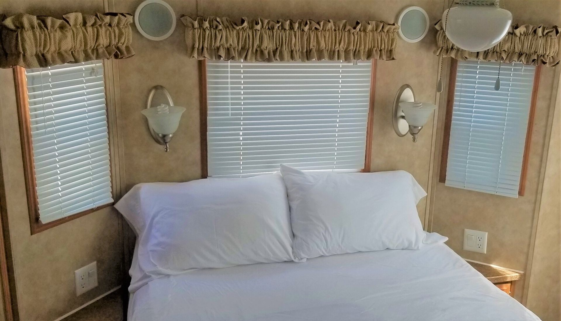 A bedroom with a bed , mirrors and blinds