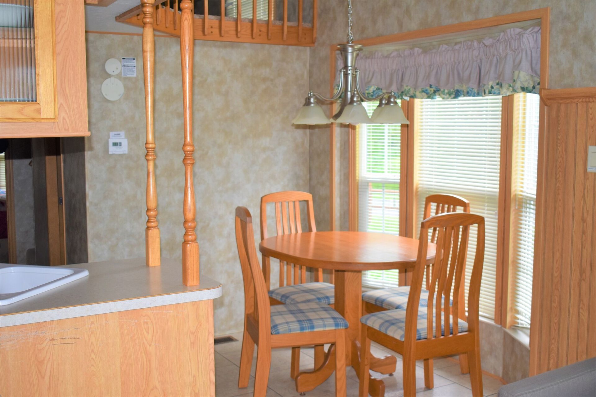 A dining room in a mobile home with a table and chairs.