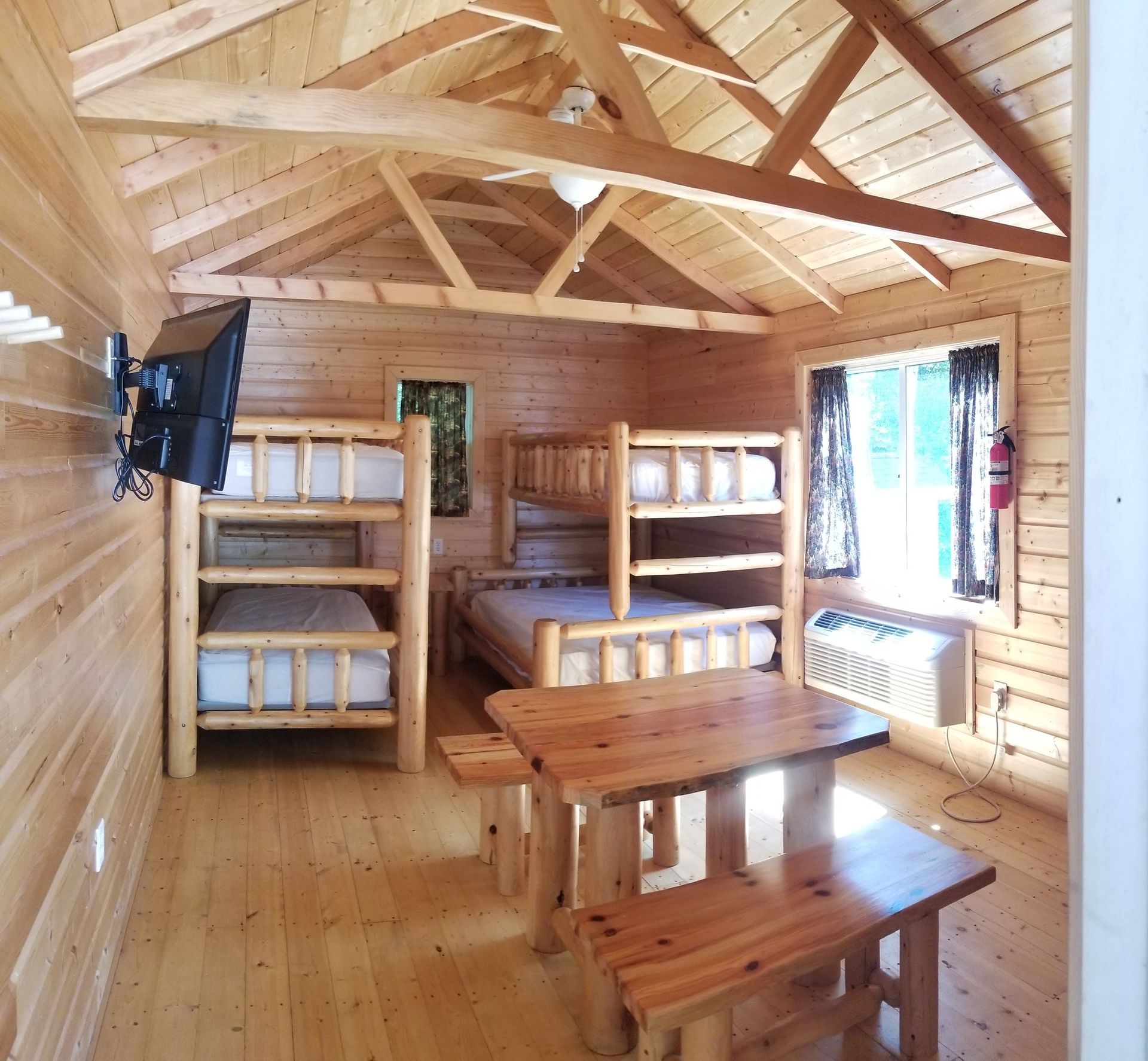 A wooden cabin with bunk beds and a table