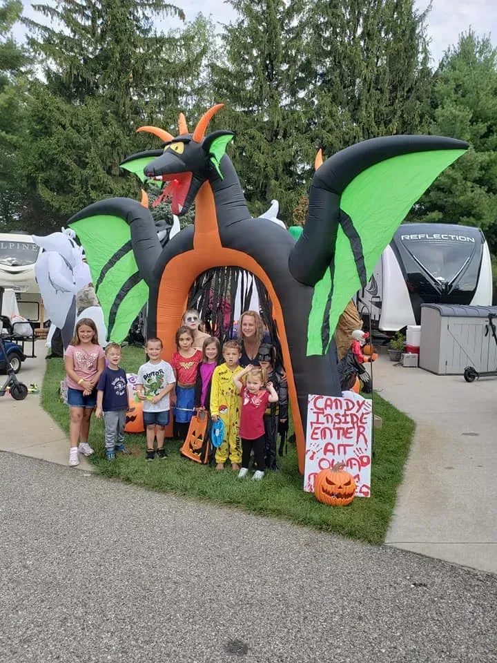 A group of children are standing in front of an inflatable dragon.