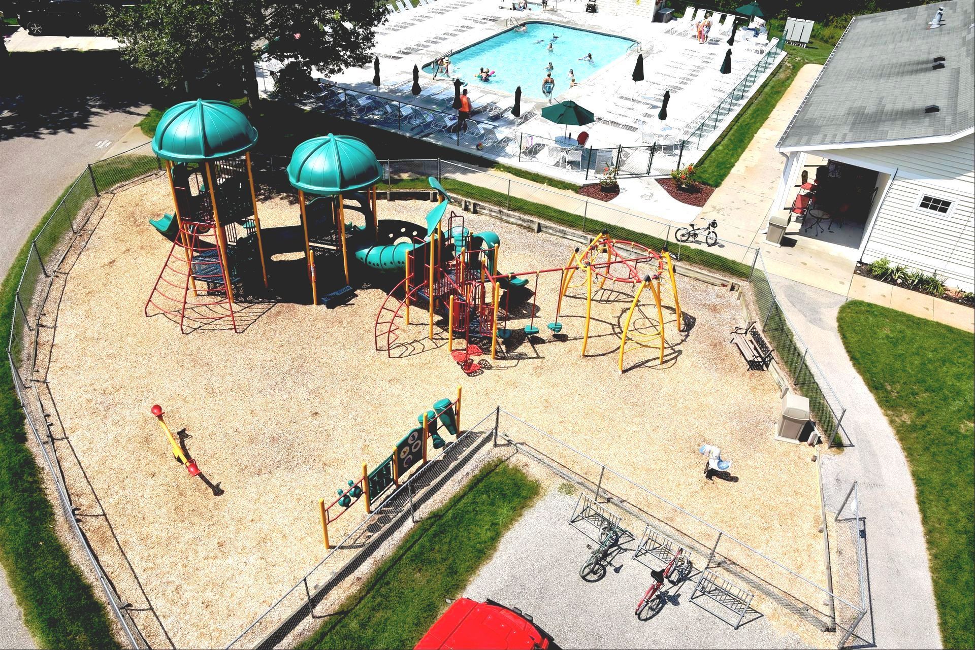 An aerial view of a playground with a pool in the background