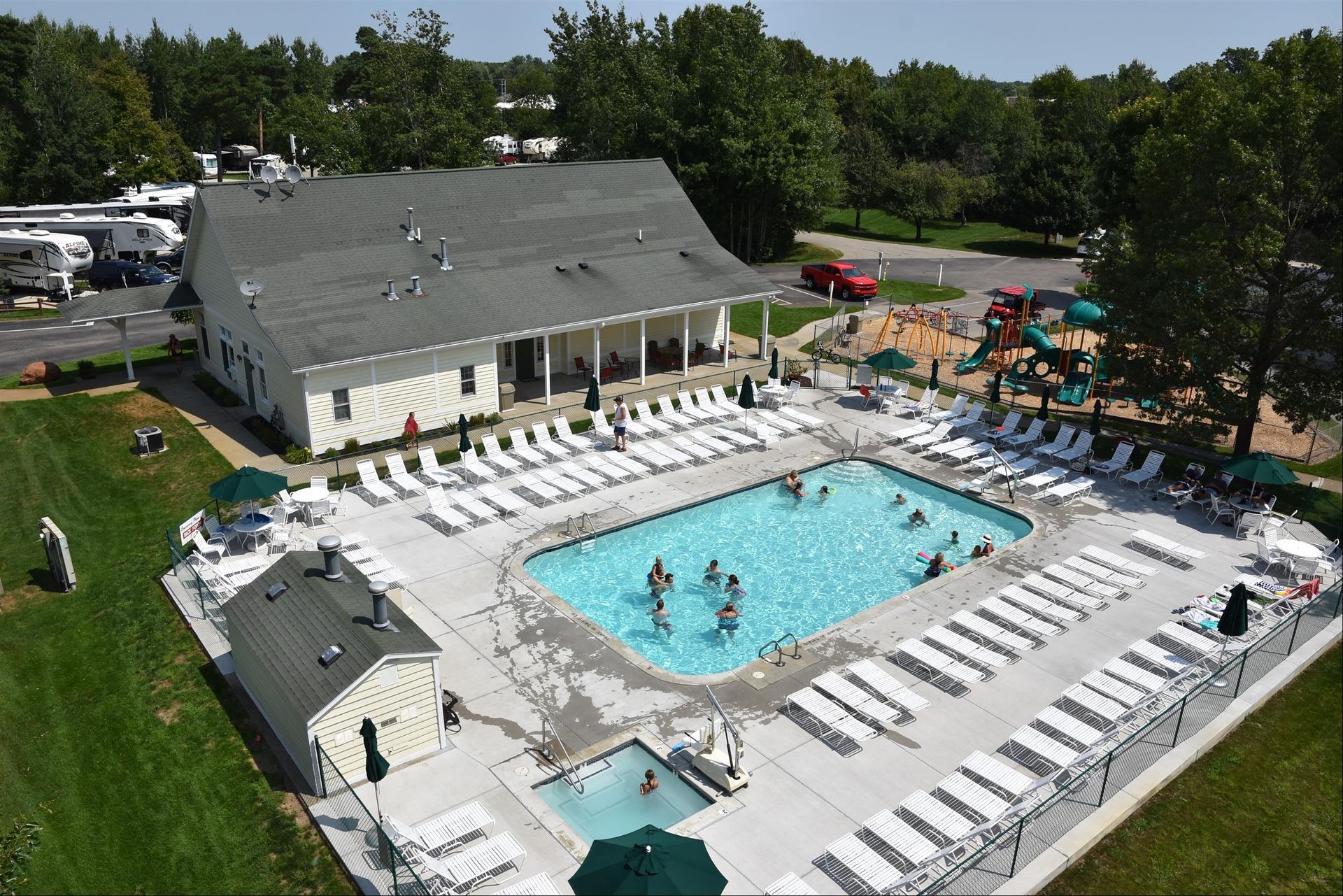 An aerial view of a large swimming pool surrounded by chairs and umbrellas.