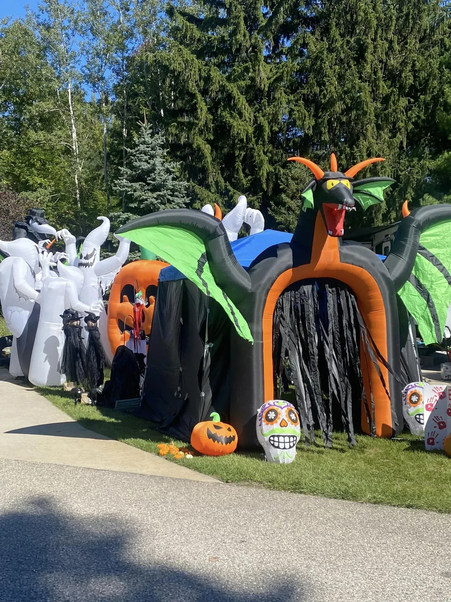 A house decorated for halloween with a dragon , ghosts , pumpkins and skulls.