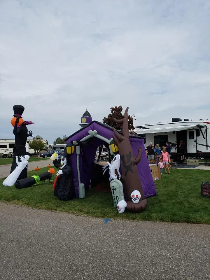 A purple house with ghosts and a tree in front of it