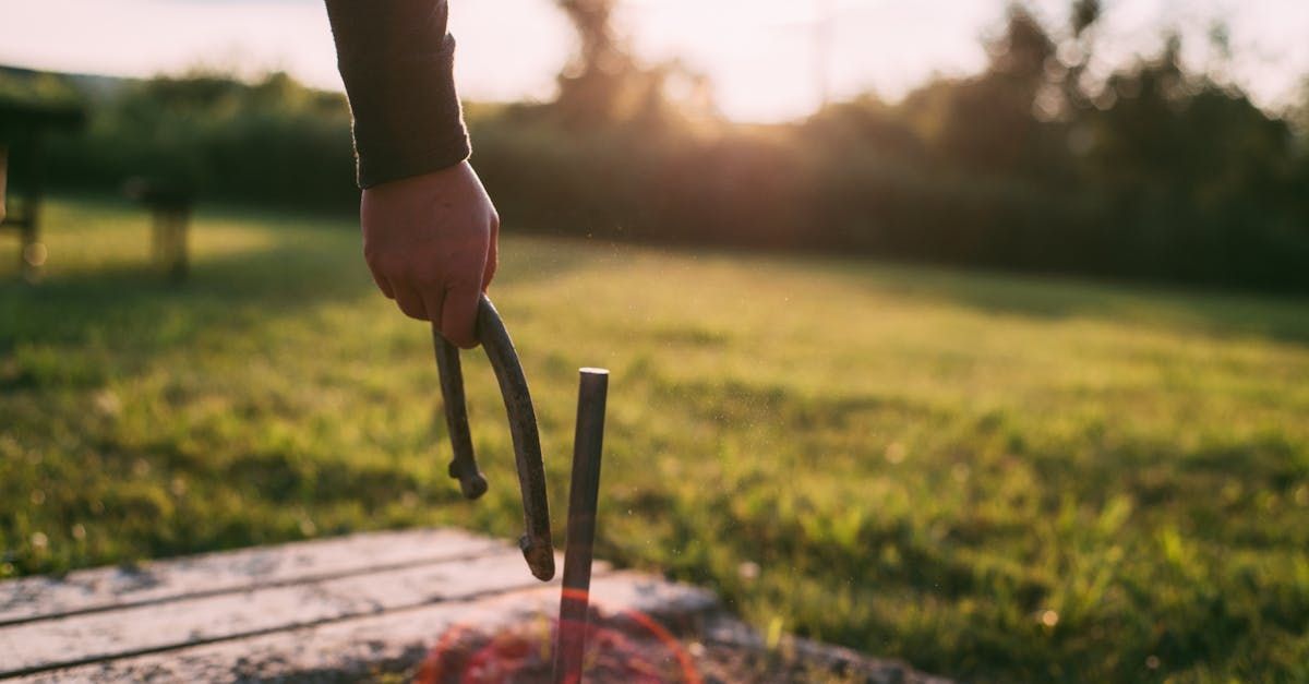 A person is holding a pair of tongs over a fire.