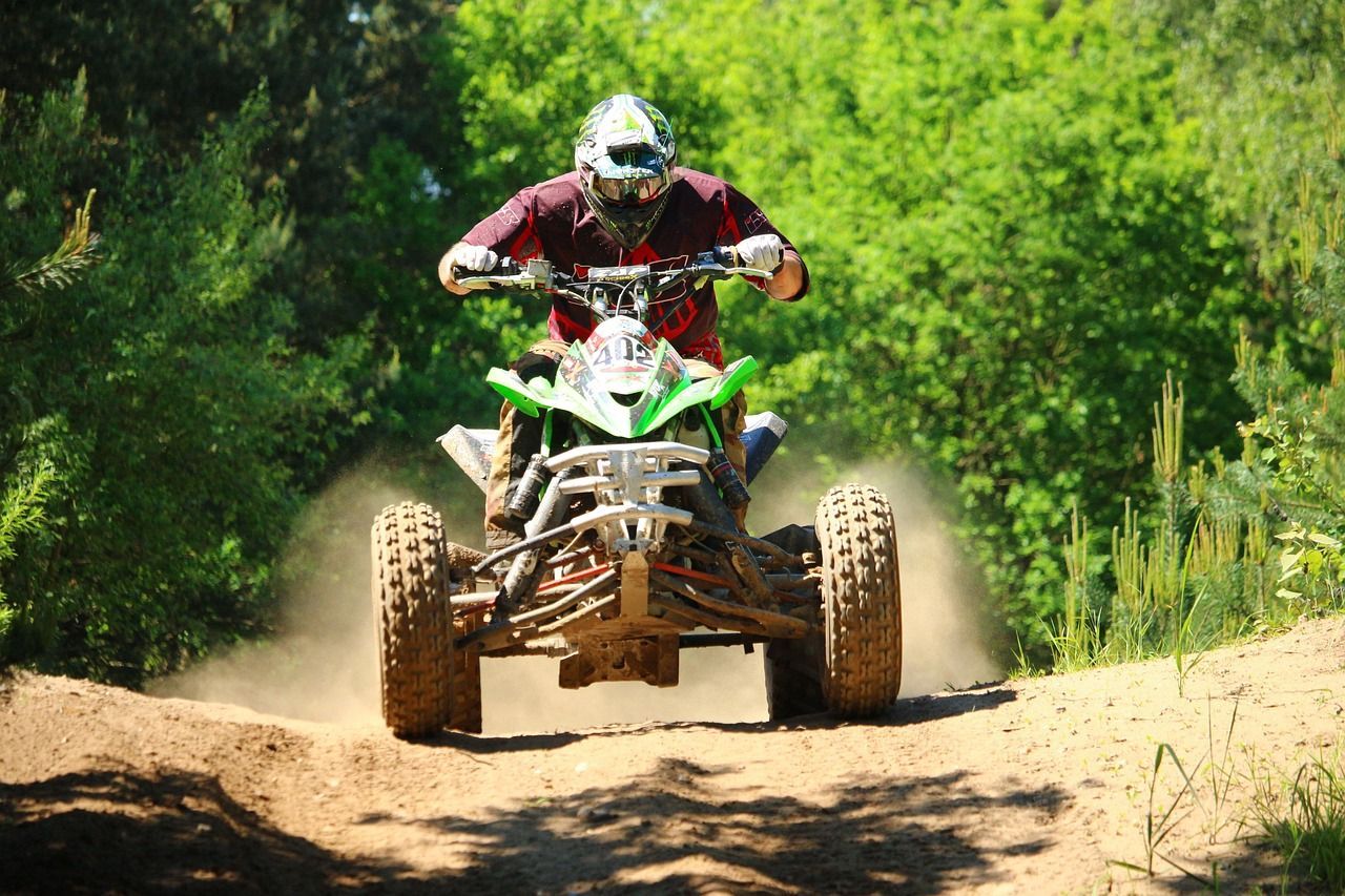 a man riding on a quad on a dusty path