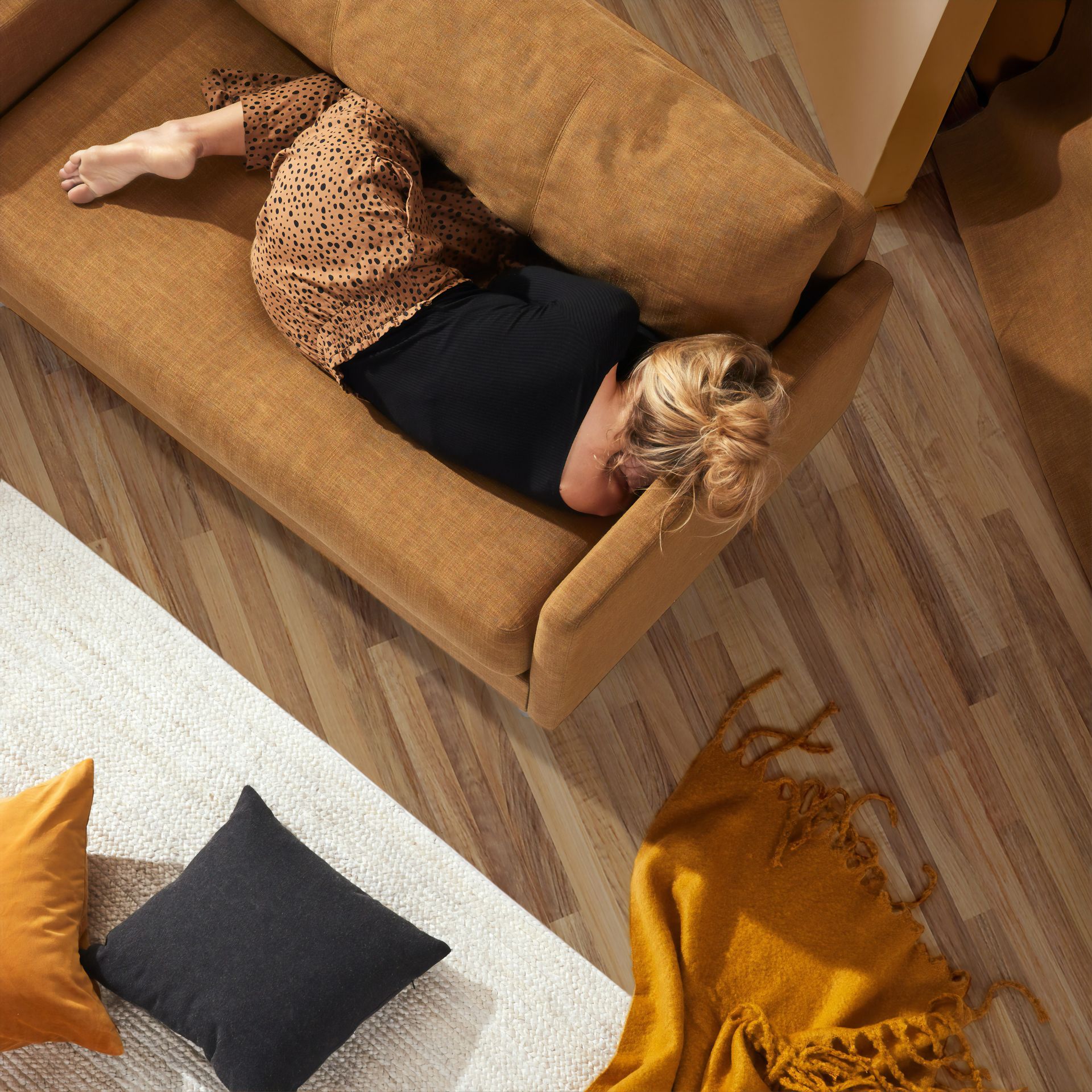 A woman is laying on a couch in a living room