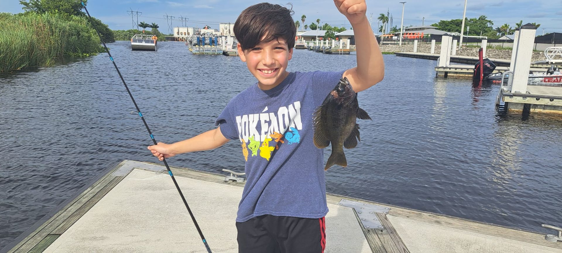 young boy happy holding a fish he caught