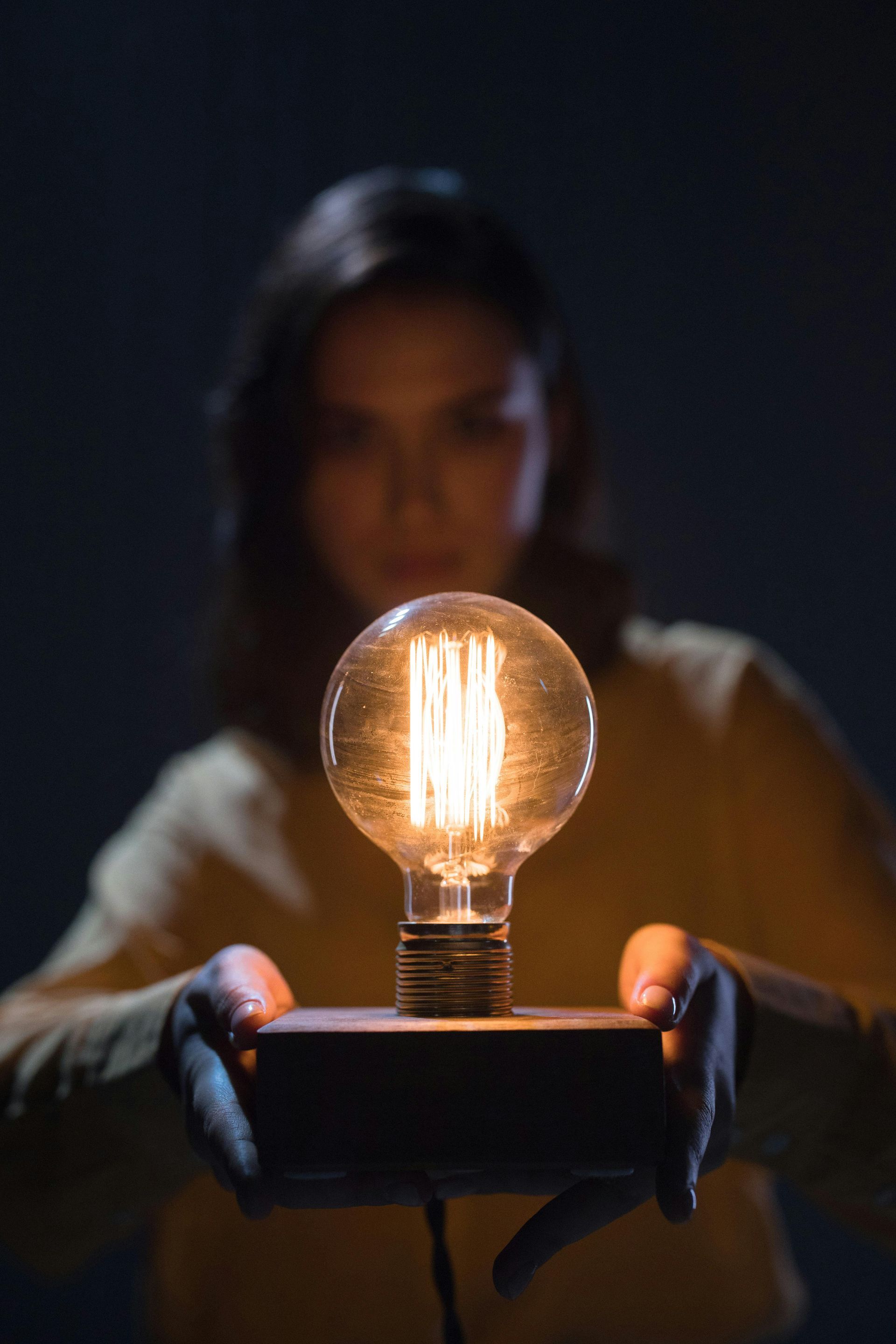 Young woman getting enlightened before a light bulb 