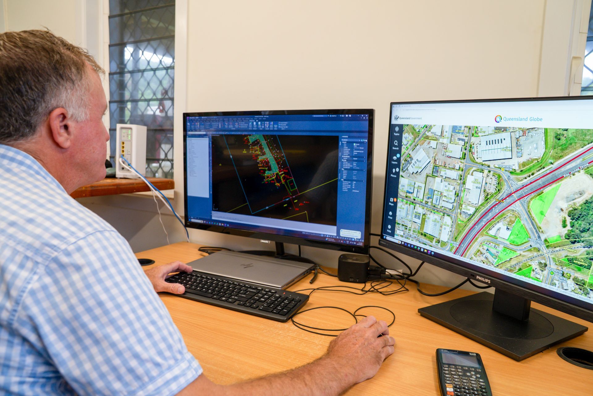 A Construction Worker Is Using A Theodolite On A Construction Site — TerraModus Surveying In Atherton Tablelands, QLD
