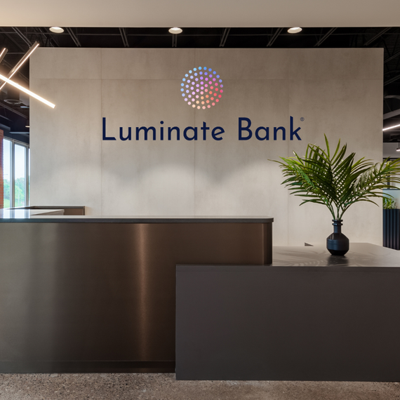 A stainless steel counter in front of a wall that says luminate bank