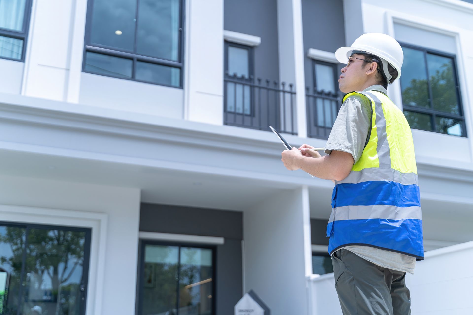 A man with a tablet is inspecting a house.