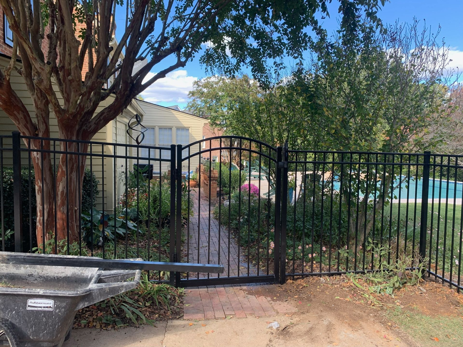 A black fence with a gate in front of a house.