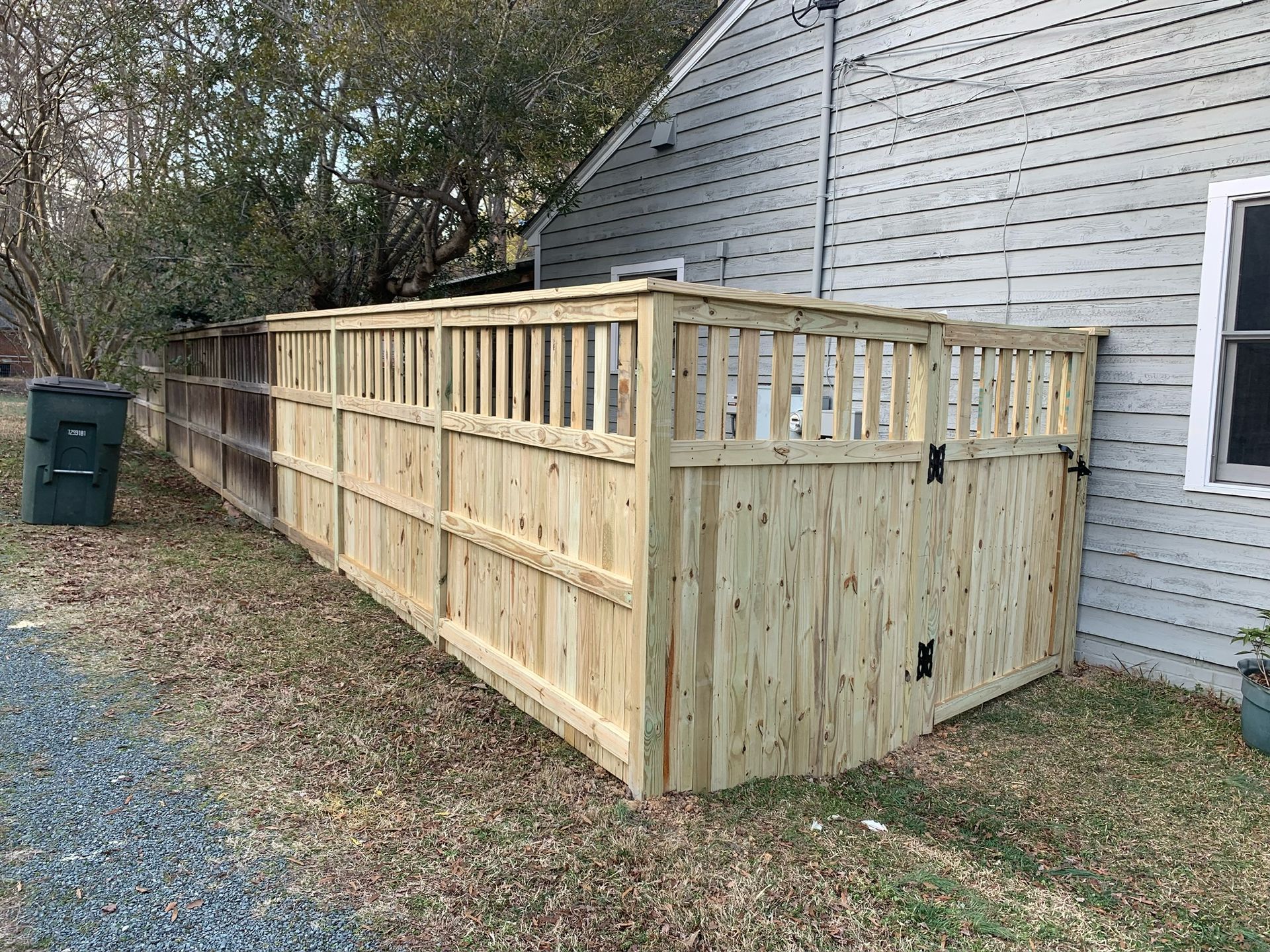 A wooden fence is sitting in front of a house.