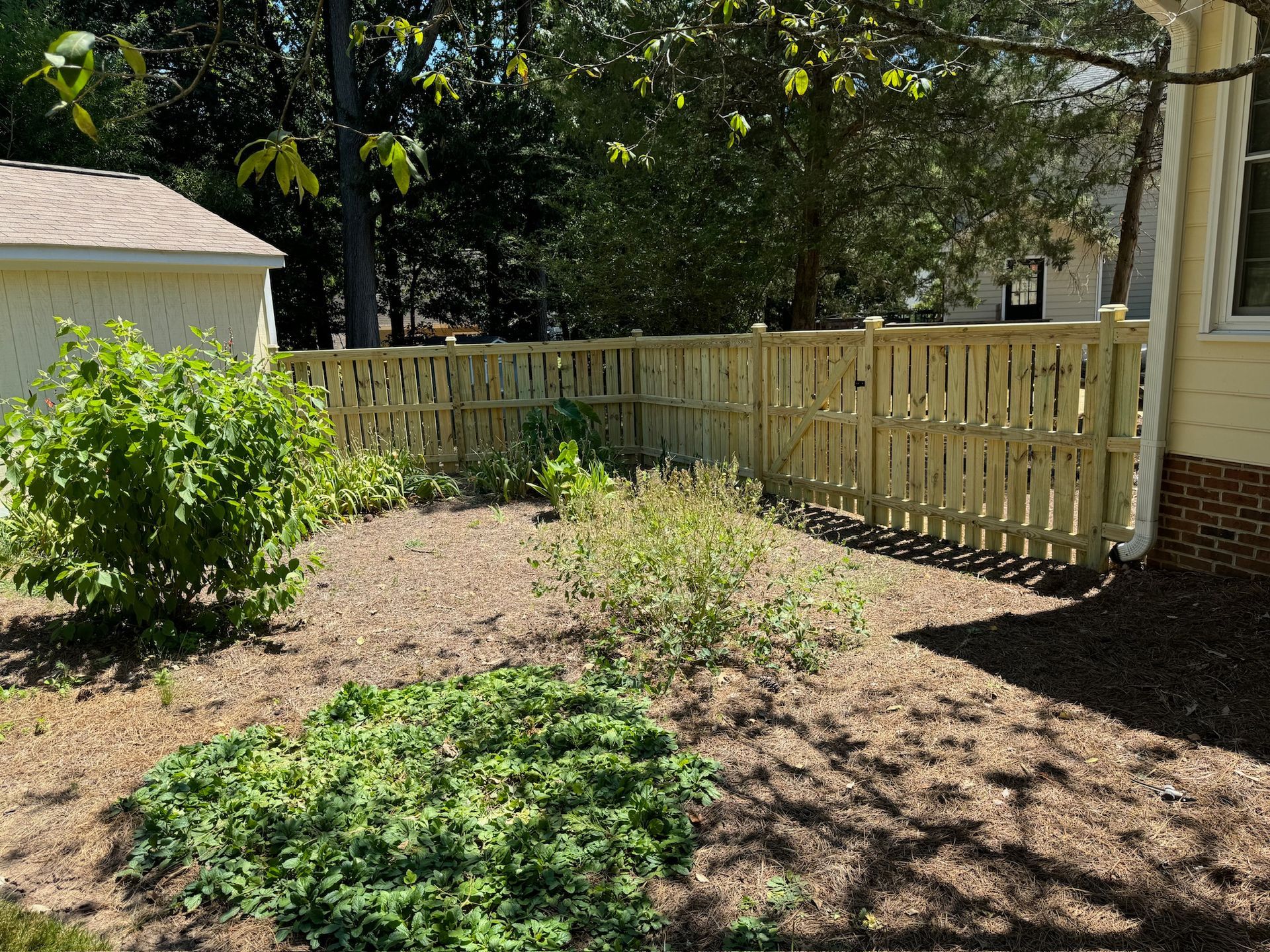 There is a wooden fence in the backyard of a house.