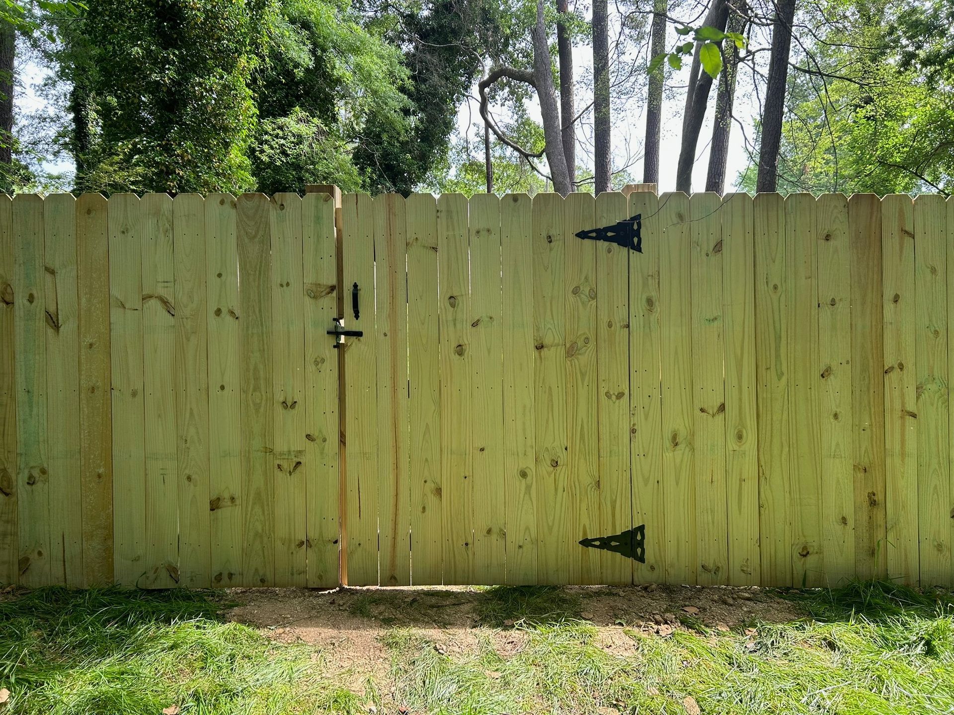 A wooden fence with a gate in the middle of it.