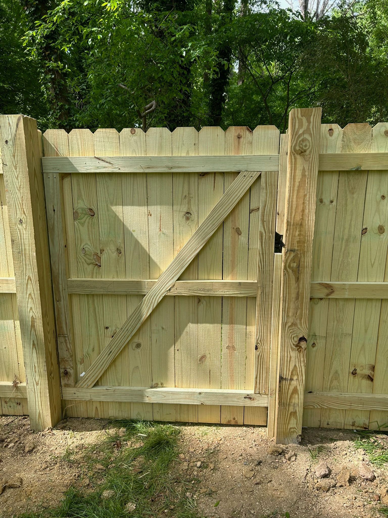 A wooden fence with a gate in the middle of it.