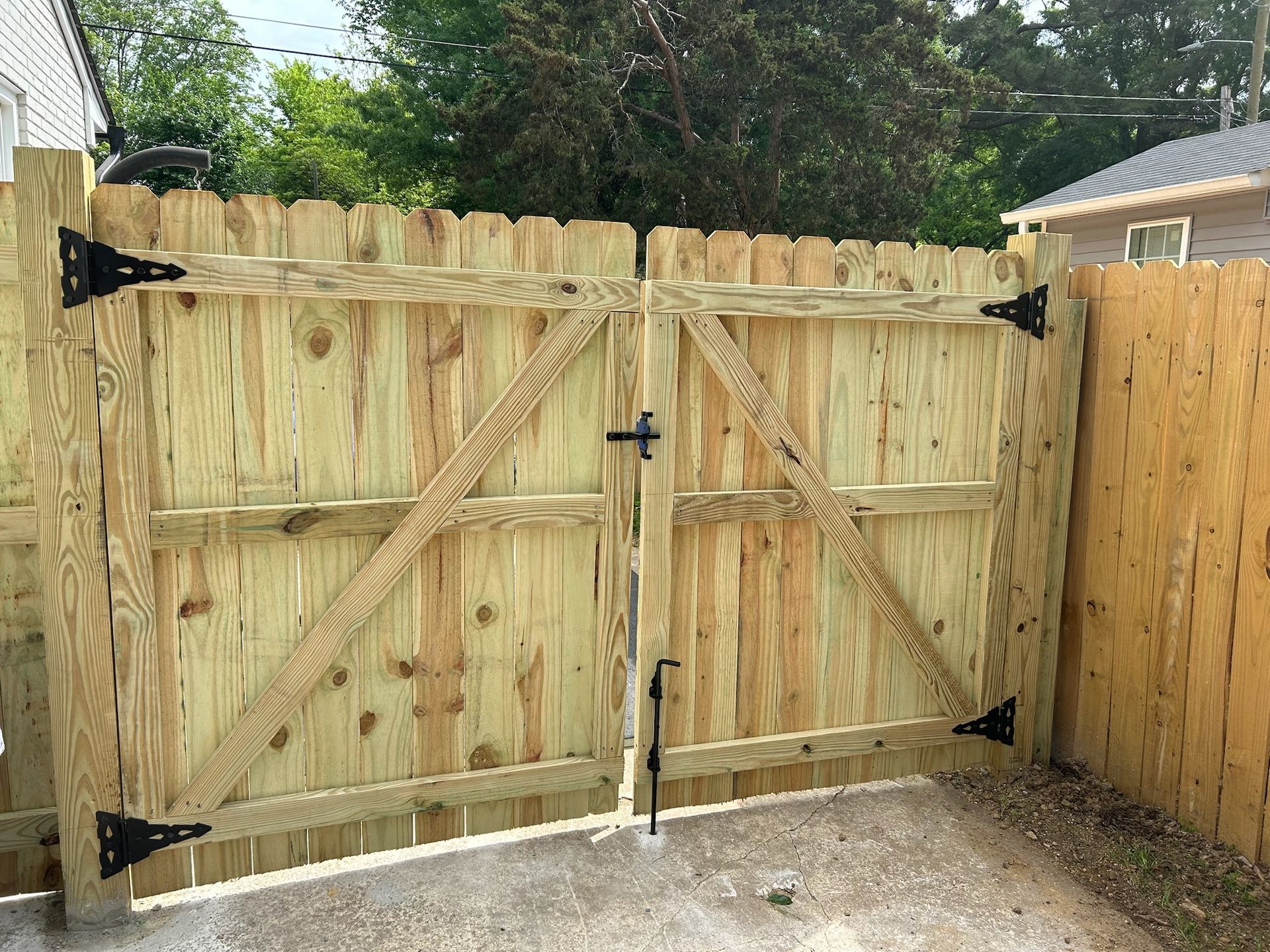 A wooden fence with a gate in the backyard of a house.