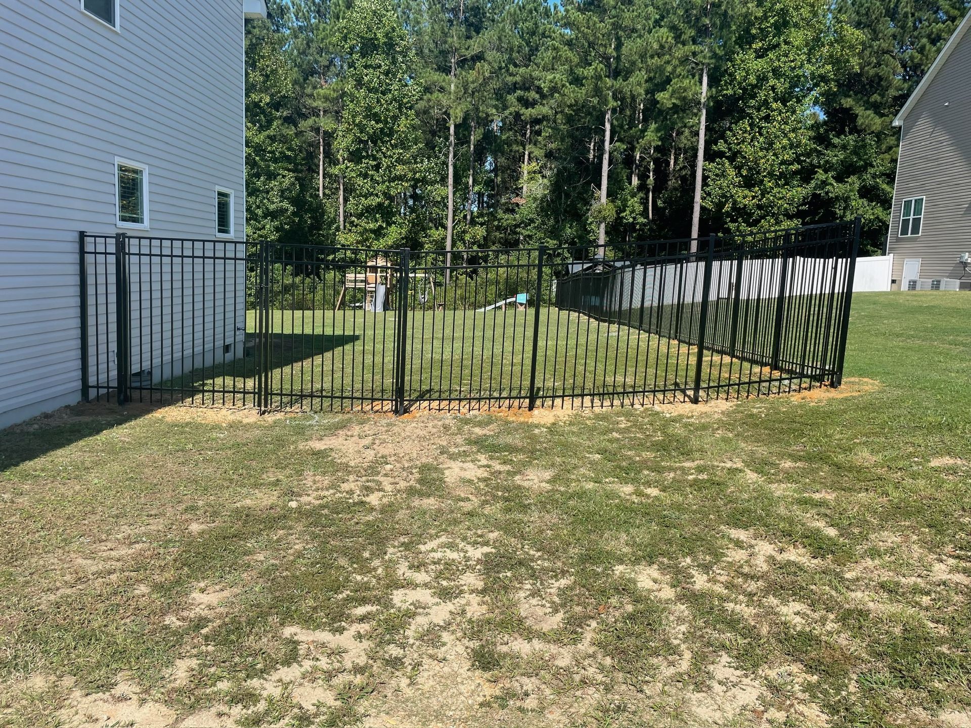 There is a fence in the backyard of a house.