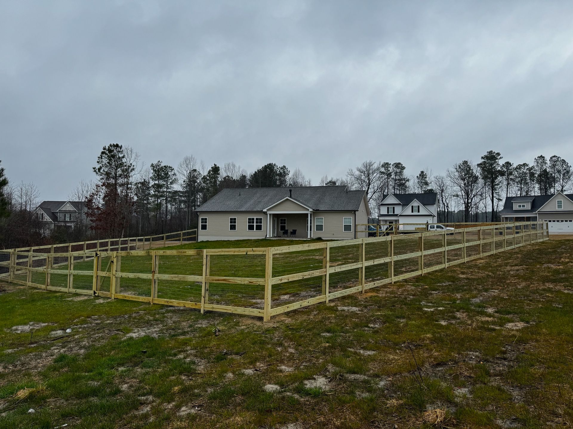 A house with a wooden fence in front of it.