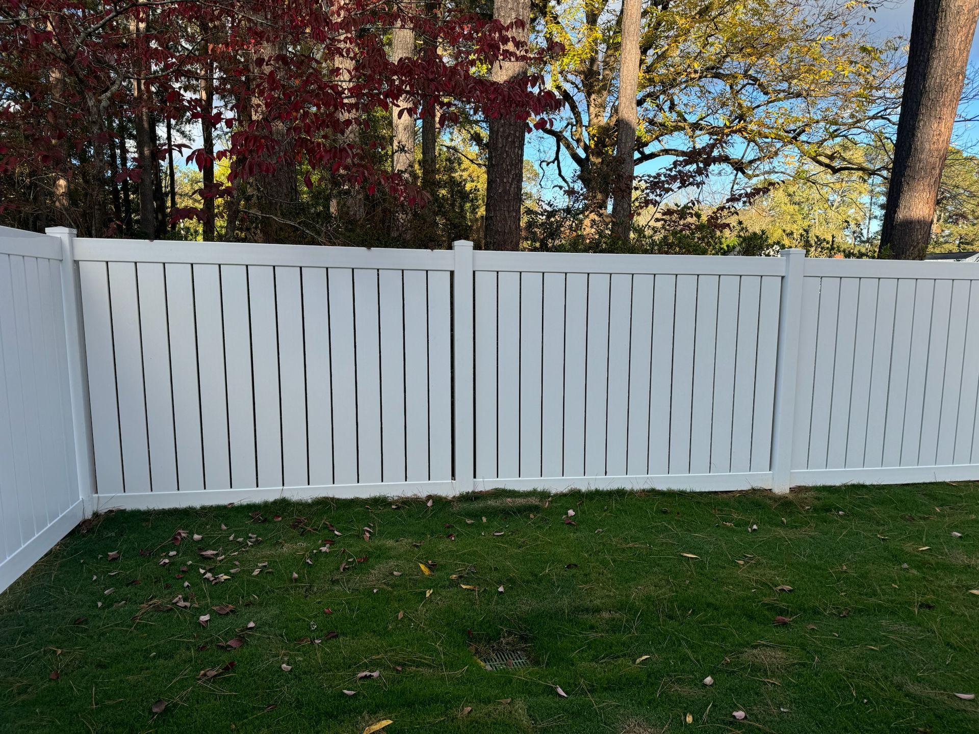 A white fence is sitting on top of a lush green lawn.
