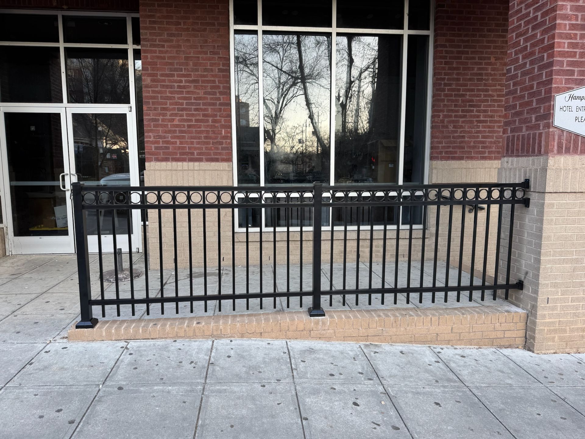 A black fence is in front of a brick building