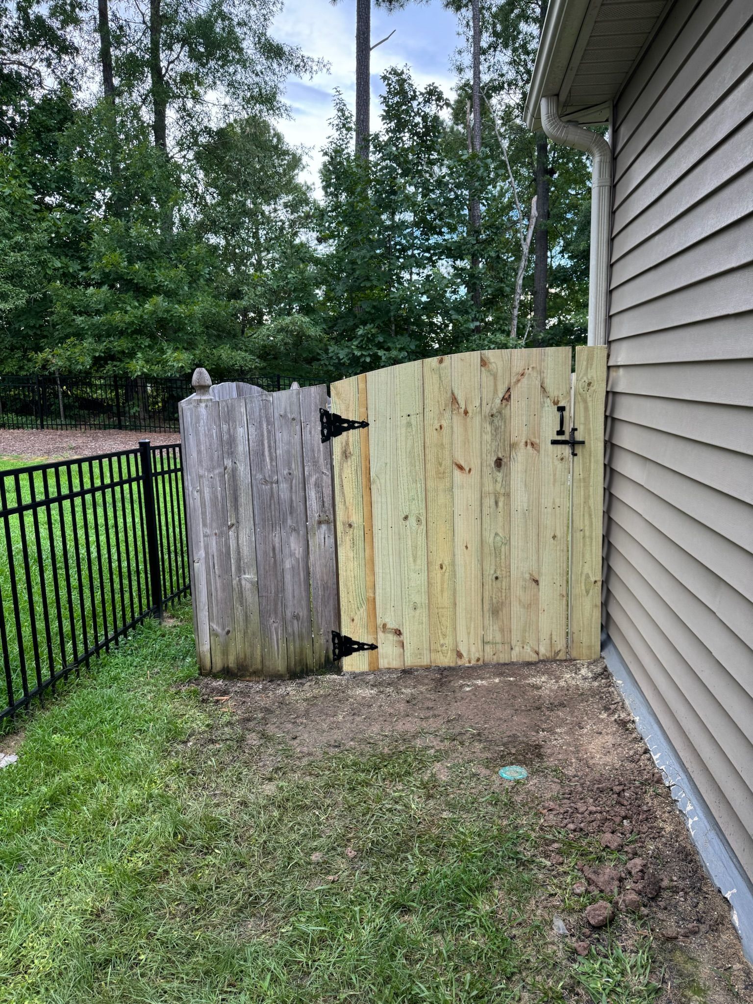 A wooden fence is sitting next to a house.